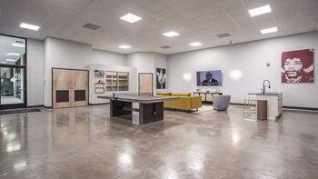 A large room with a ping pong table and couches 