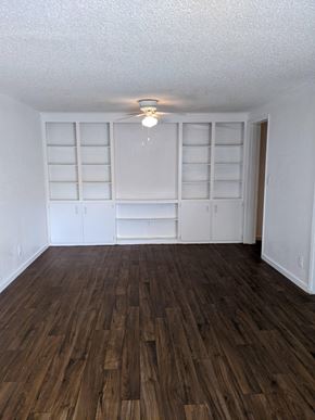 Cocoa apartment for rent - an empty living room with a wood floor and white shelves