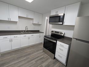 Cocoa apartment for rent - A kitchen with white cabinets and a black oven.