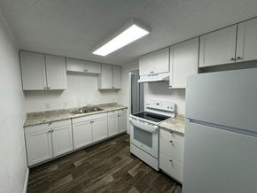 Melbourne apartment for rent - an empty kitchen with white cabinets and white appliances