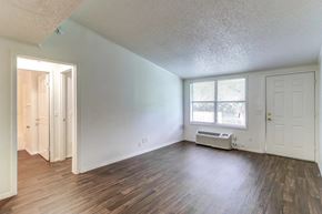 Melbourne apartment for rent - an empty living room with wood flooring and a window