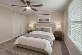 Titusville apartment for rent - A bedroom with a bed, two lamps, and a painting on the wall.