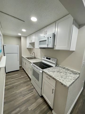 Daytona Beach apartment for rent - A kitchen with white cabinets and appliances.