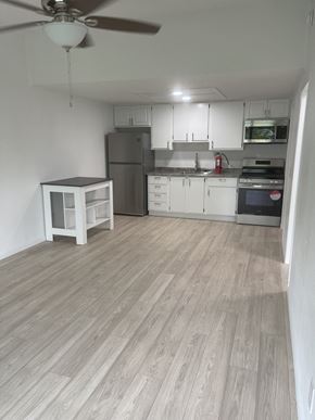 Port Orange apartment for rent - A kitchen with a wooden wall and white appliances.