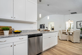 Clayton apartment for rent - A modern kitchen with white cabinets and a wooden countertop.