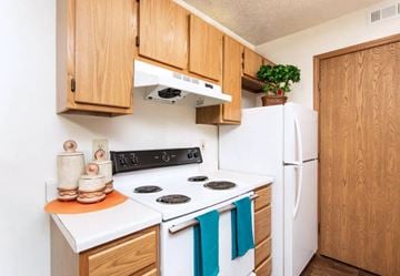 Delaware apartment for rent - A kitchen with wooden cabinets and a white stove top oven.