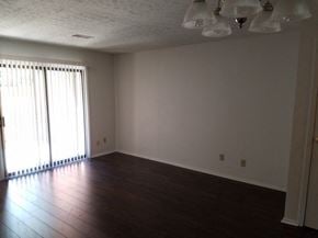Westerville triplex for rent - an empty living room with wood floors and a window