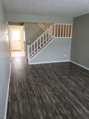 Hilliard townhouse for rent - an empty living room with wood floors and a staircase