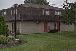 Columbus triplex for rent - a white house with a red door and a yard
