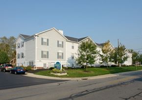 Columbus apartment for rent - A large white building with a green sign in front of it.