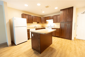 Salem apartment for rent - A kitchen with wooden cabinets and a white refrigerator.