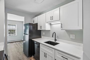 Manchester apartment for rent - A kitchen with black and white cabinets and a black fridge.