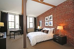 Boston apartment for rent - a bedroom with a bed and a brick wall
