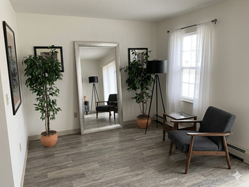 Manchester apartment for rent - A living room with a grey chair and a potted plant.