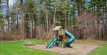 Seabrook apartment for rent - A playground with a green slide and a wooden structure.