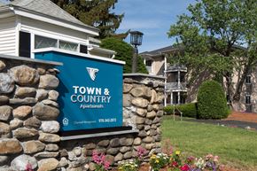 Leominster apartment for rent - A sign for Town & Country Apartments is displayed on a stone wall.