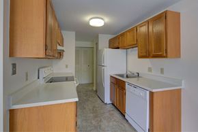 Leominster apartment for rent - A kitchen with wooden cabinets and white appliances.