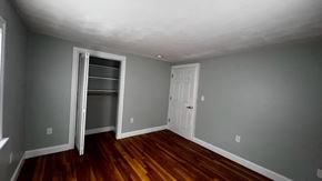 Quincy apartment for rent - A room with a wooden floor and a white door.