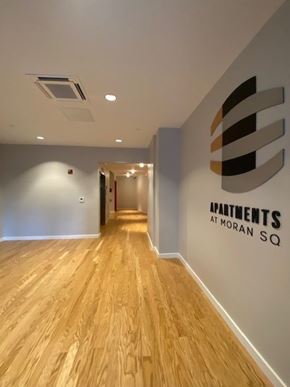 Fitchburg apartment for rent - A hallway with a logo on the wall that says "Apartments at Moran Sq".