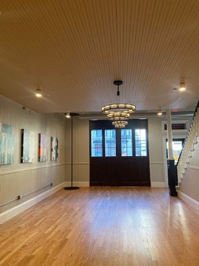 Fitchburg apartment for rent - A room with wooden floors and a chandelier hanging from the ceiling.