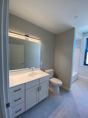 Fitchburg apartment for rent - A bathroom with a sink, toilet, and mirror.