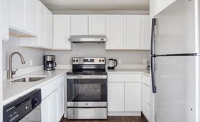 Boston apartment for rent - a white kitchen with stainless steel appliances and white cabinets