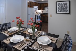 Derry apartment for rent - a dining room table with plates and flowers in a kitchen