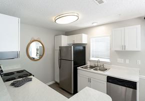 Durham apartment for rent - A kitchen with a black fridge and stove top oven.