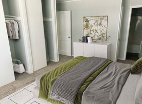 Fayetteville apartment for rent - A bedroom with a bed covered in a green and grey blanket.