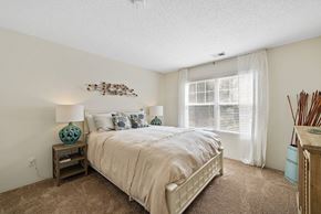 Bluffton apartment for rent - A bedroom with a large bed and a wooden nightstand.