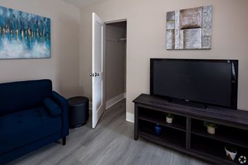 Allentown apartment for rent - A living room with a blue couch, a television, and a painting on the wall.