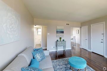 Collingswood apartment for rent - A living room with a grey couch and a blue ottoman.
