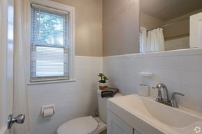 Allentown apartment for rent - A white bathroom with a toilet, sink, and window.