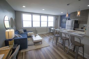 Philadelphia apartment for rent - A modern living room with a blue couch and a wooden coffee table.