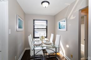 Pitman apartment for rent - A dining room with a glass table and white chairs.