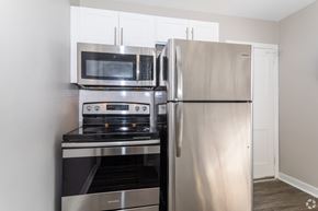 Pitman apartment for rent - A kitchen with a stainless steel refrigerator, oven, and microwave.