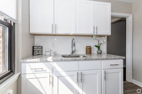 Pitman apartment for rent - A kitchen with white cabinets and a marble countertop.
