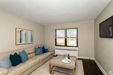 Pitman apartment for rent - A living room with a beige couch, a coffee table, and a painting on the wall.