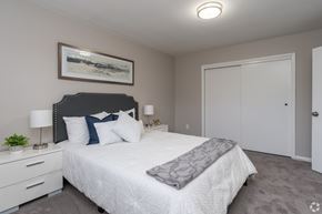 Pottstown apartment for rent - A bedroom with a large bed and a painting on the wall.