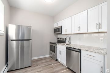 Pottstown apartment for rent - A kitchen with a stainless steel refrigerator and white cabinets.