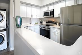 Newark apartment for rent - A modern kitchen with white cabinets and stainless steel appliances.