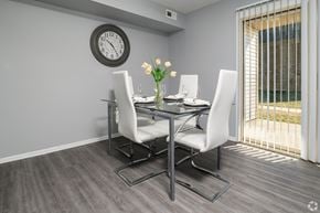 Newark apartment for rent - A dining table with four chairs and a clock on the wall.