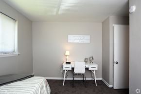 Secane apartment for rent - A small bedroom with a bed, desk, and chair.