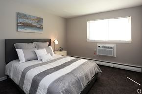 Secane apartment for rent - A bedroom with a large bed and a painting on the wall.