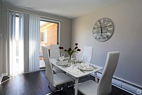 Secane apartment for rent - A dining room with a table set for two and a clock on the wall.