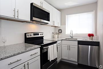Secane apartment for rent - A kitchen with black and white cabinets and appliances.