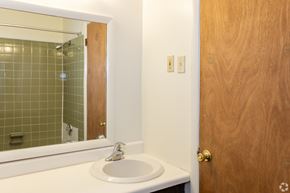 Bethlehem apartment for rent - A bathroom with a sink, mirror, and wooden door.