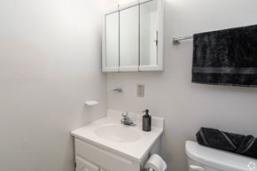 Bethlehem apartment for rent - A white bathroom with a sink, mirror, and toilet paper roll.