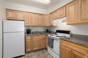 Bethlehem apartment for rent - A kitchen with wooden cabinets and a white fridge.
