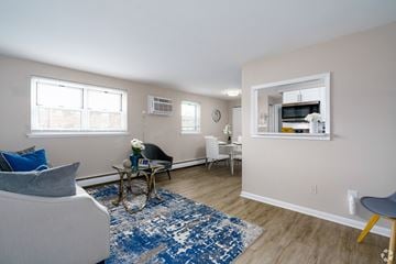 Bensalem apartment for rent - A living room with a blue rug and a grey armchair.